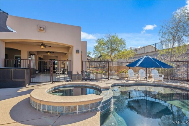 view of pool with a ceiling fan, a pool with connected hot tub, fence, and a patio