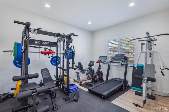 exercise area with baseboards, wood finished floors, and recessed lighting