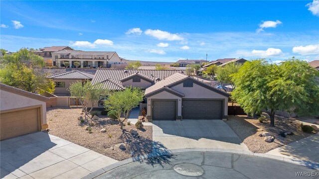 view of front facade with driveway, an attached garage, a residential view, and stucco siding