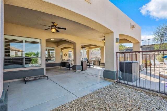 view of patio with fence, an outdoor hangout area, and a ceiling fan