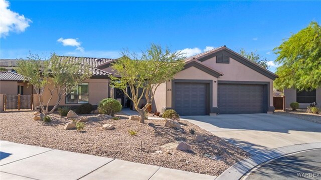 ranch-style home with a tile roof, driveway, an attached garage, and stucco siding