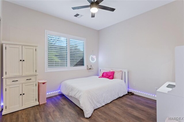 bedroom with dark wood-style floors, visible vents, baseboards, and a ceiling fan