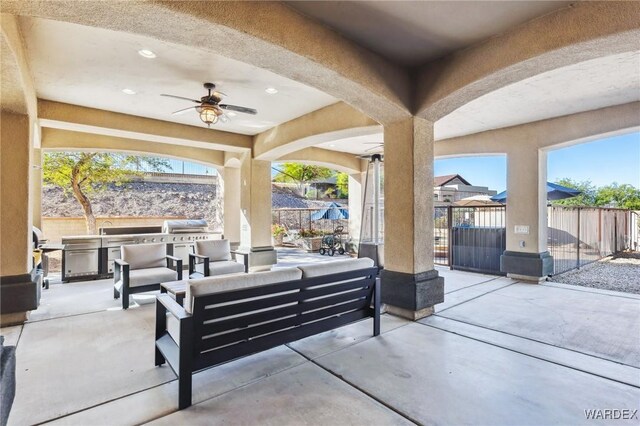 view of patio / terrace featuring exterior kitchen, outdoor lounge area, fence, and a ceiling fan