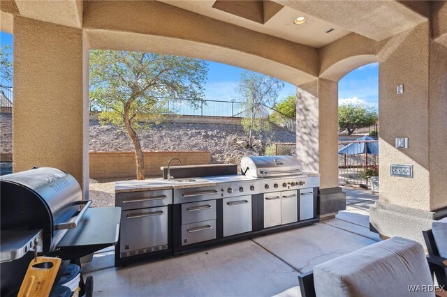 view of patio / terrace featuring fence, exterior kitchen, and area for grilling