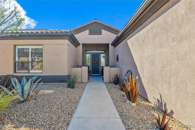 view of exterior entry featuring stucco siding