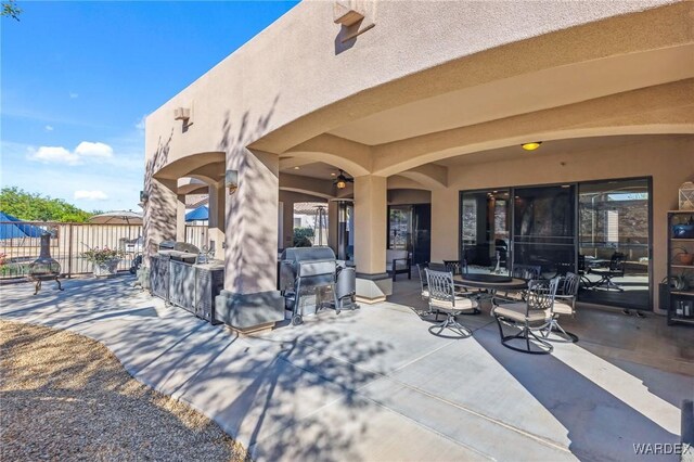 view of patio featuring a grill and fence