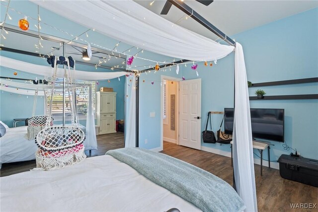 bedroom with dark wood finished floors and baseboards