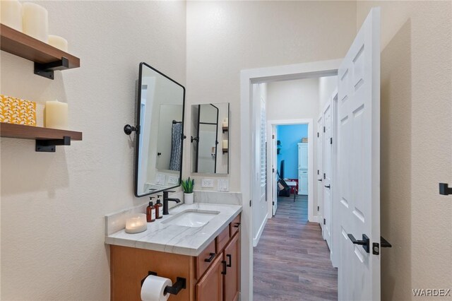 bathroom with wood finished floors, vanity, and baseboards