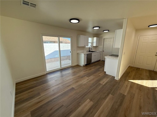 kitchen with light countertops, visible vents, stainless steel dishwasher, white cabinets, and a sink