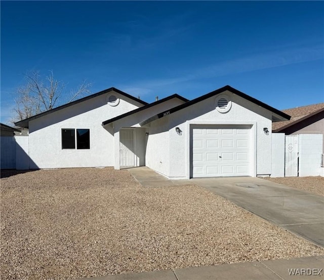 ranch-style home with concrete driveway, an attached garage, and stucco siding