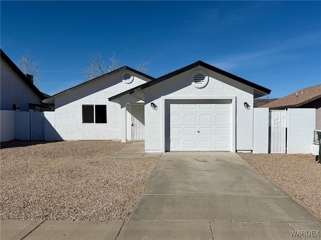 ranch-style house featuring driveway, an attached garage, and stucco siding