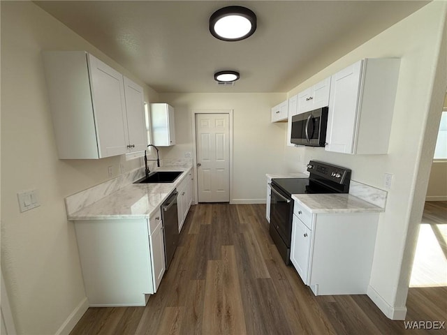 kitchen with baseboards, dark wood finished floors, stainless steel appliances, white cabinetry, and a sink