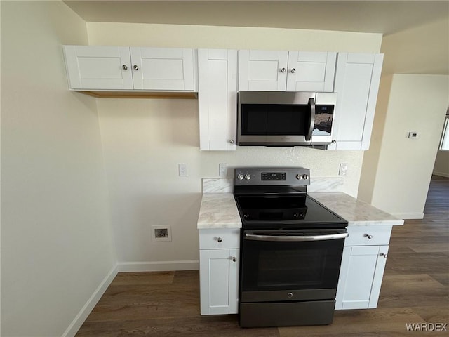 kitchen featuring white cabinetry, stainless steel appliances, and dark wood finished floors