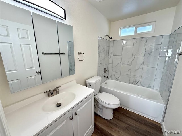 bathroom featuring toilet, bathing tub / shower combination, vanity, and wood finished floors