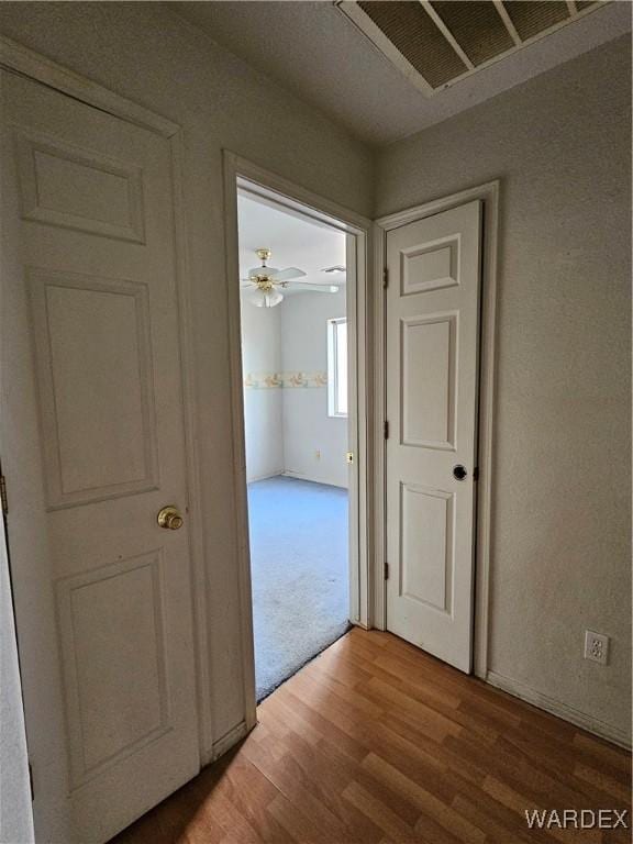 corridor featuring visible vents and wood finished floors