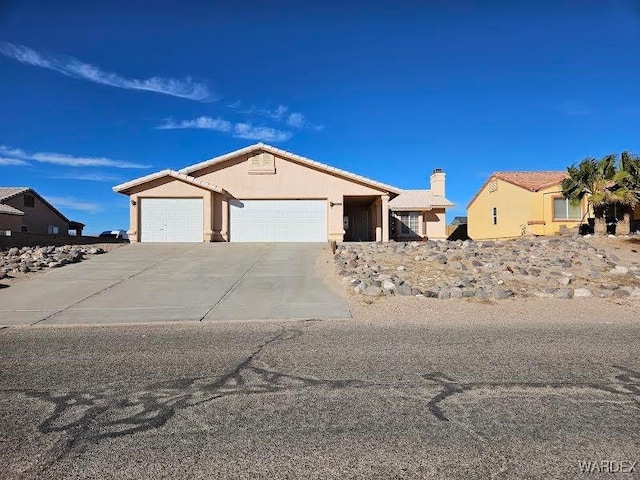 view of front of property with an attached garage, driveway, and stucco siding