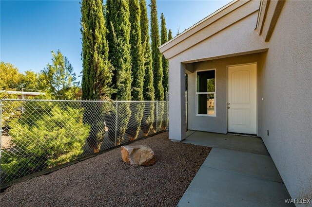 entrance to property with fence and stucco siding