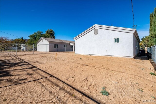 rear view of house with fence and stucco siding