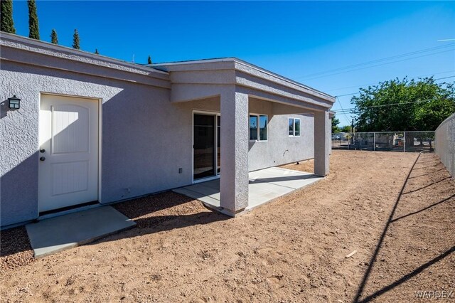 back of house with a patio area, fence, and stucco siding