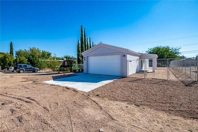 garage with driveway and fence