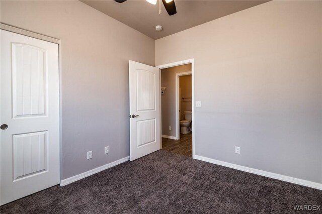 unfurnished bedroom featuring ceiling fan, baseboards, and dark colored carpet