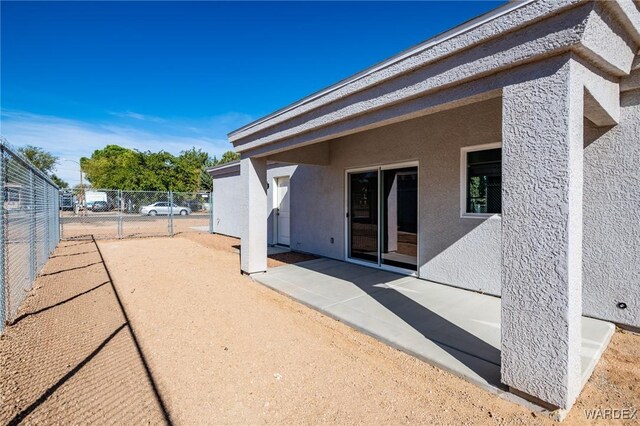 back of house with a patio area, fence, and stucco siding