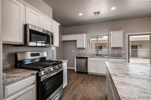 kitchen with white cabinetry, visible vents, appliances with stainless steel finishes, and a sink