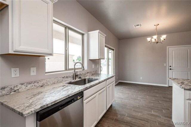 kitchen with a sink, visible vents, white cabinets, stainless steel dishwasher, and pendant lighting