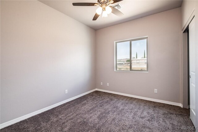 carpeted empty room featuring visible vents, a ceiling fan, and baseboards