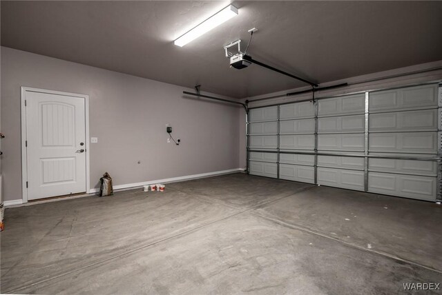 garage featuring a garage door opener and baseboards