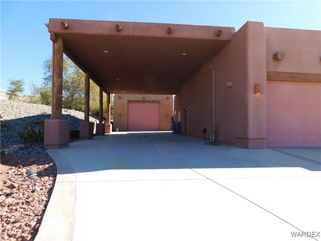 exterior space with a garage, driveway, and stucco siding