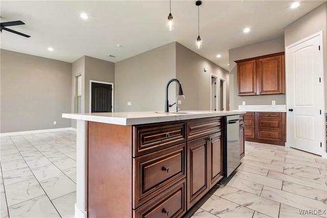 kitchen with marble finish floor, light countertops, a sink, and a center island with sink