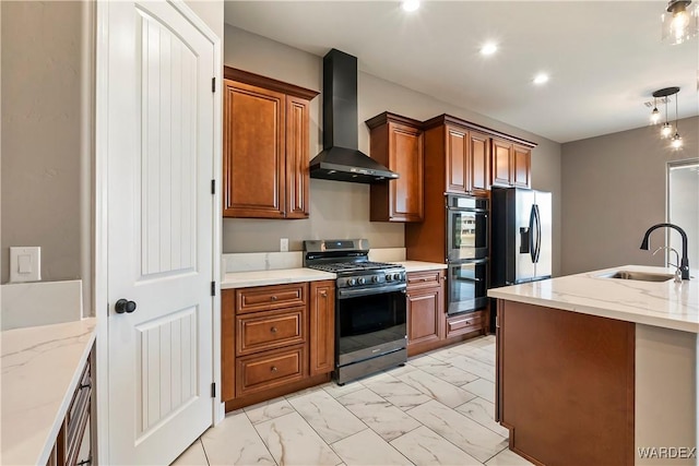 kitchen with marble finish floor, appliances with stainless steel finishes, brown cabinetry, a sink, and wall chimney exhaust hood