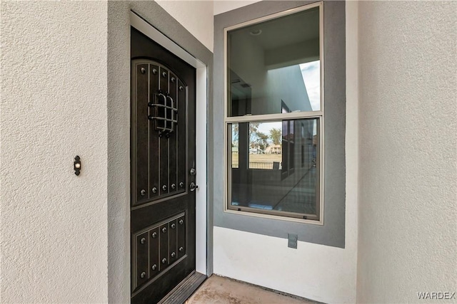 doorway to property featuring stucco siding