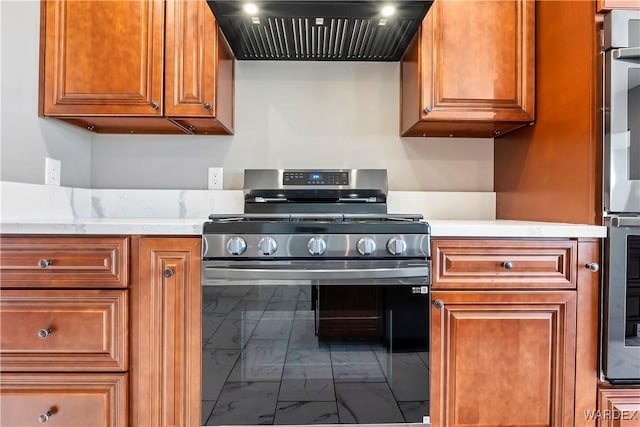 kitchen featuring marble finish floor, stainless steel gas range oven, range hood, and brown cabinets