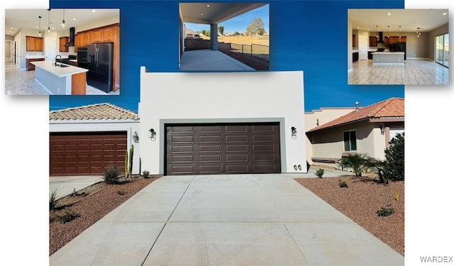 view of front of home with a garage, a sink, driveway, and stucco siding