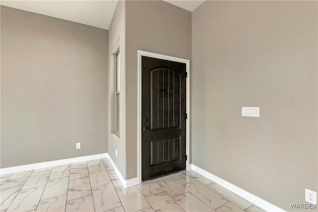 foyer with marble finish floor and baseboards