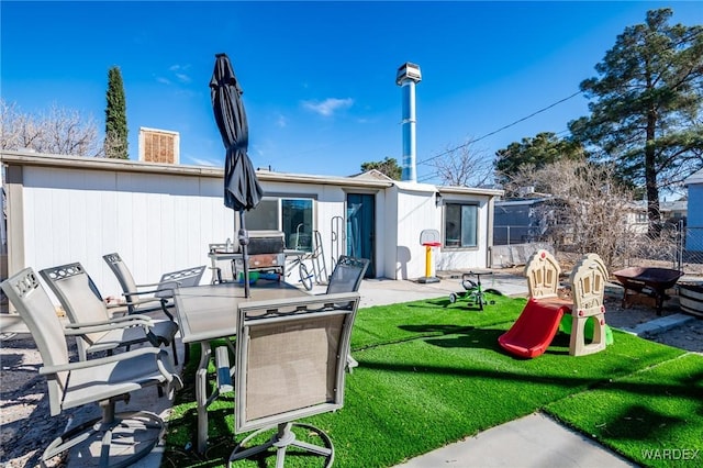 back of property featuring outdoor dining area, a lawn, fence, and a patio