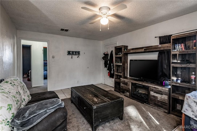 tiled living area with ceiling fan, visible vents, and a textured ceiling