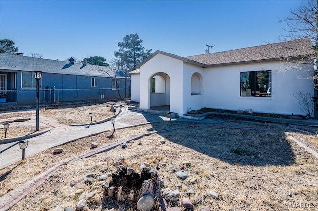 view of front of property featuring fence and stucco siding