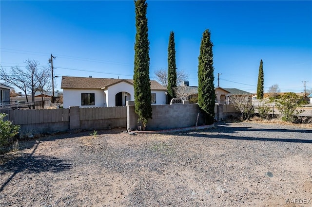 view of front of property with a fenced front yard and stucco siding