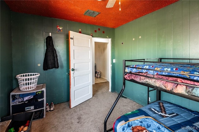 bedroom with carpet floors, visible vents, and a textured ceiling