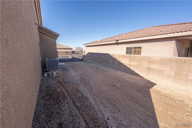 view of yard with fence and central air condition unit