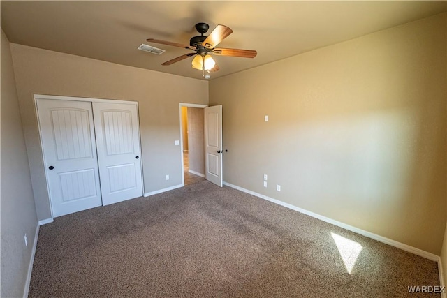 unfurnished bedroom with carpet floors, a closet, visible vents, and baseboards