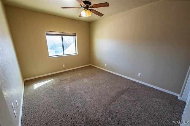 carpeted empty room with ceiling fan and baseboards