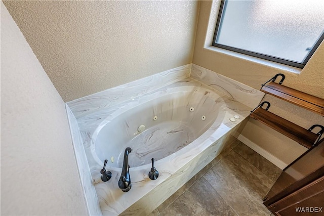 full bath featuring a whirlpool tub and a textured wall