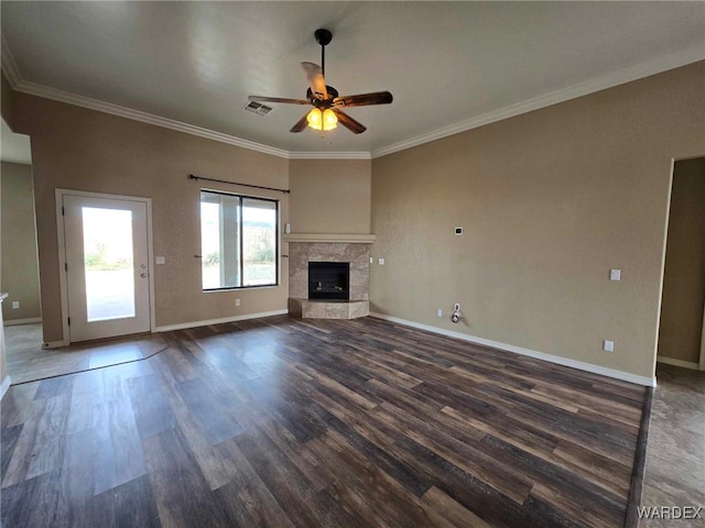 unfurnished living room featuring ornamental molding, a tile fireplace, dark wood finished floors, and baseboards