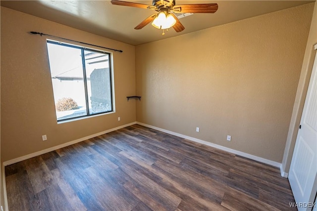 empty room featuring ceiling fan, baseboards, and dark wood-style flooring