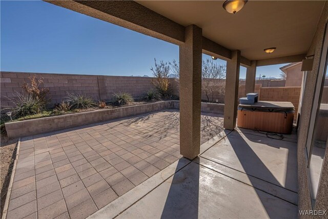 view of patio / terrace with a fenced backyard and a hot tub