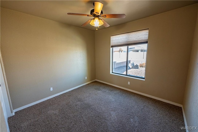 carpeted spare room featuring a ceiling fan and baseboards